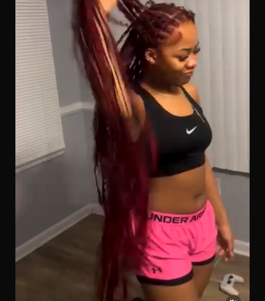 Waist-length burgundy braids held in a ponytail